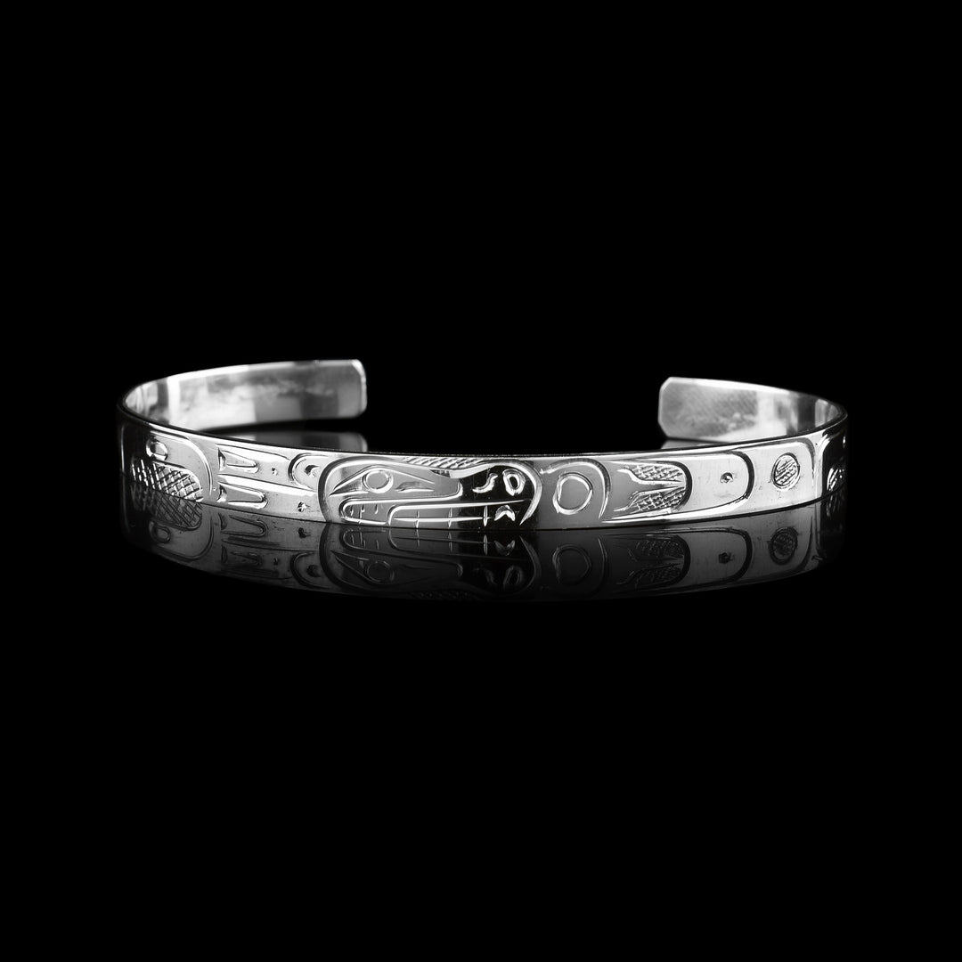  Bear Bracelet Cuff is hand carved by Coast Salish artist Graham Henry. The Bears side profile is carved on the op of the sterling silver cuff. There is amazing detail that showcase the legend through the bracelet. 