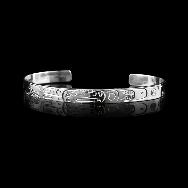  Bear Bracelet Cuff is hand carved by Coast Salish artist Graham Henry. The Bears side profile is carved on the op of the sterling silver cuff. There is amazing detail that showcase the legend through the bracelet. 