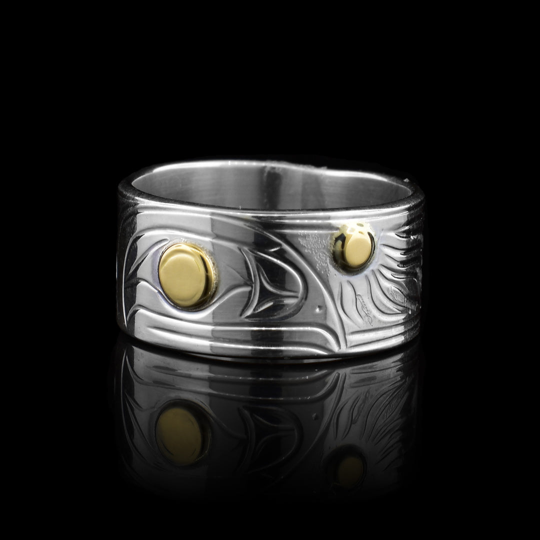 This sterling silver 14k gold Raven and Sun band ring is unique with it carving of the legend of the raven facing the legend of the sun. The ravens eye is made with 14k gold along with the middle of the sun. The rest is sterling silver band.
