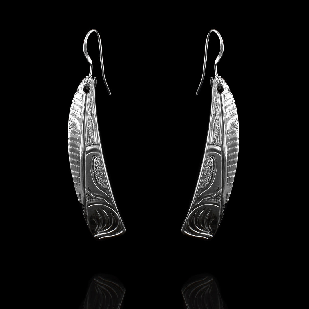 These rounded triangle dangling Wolf earrings are made from sterling silver and have rounded, triangle shaped hangs. There are carvings on the surface of the hangs depiction the Wolf.