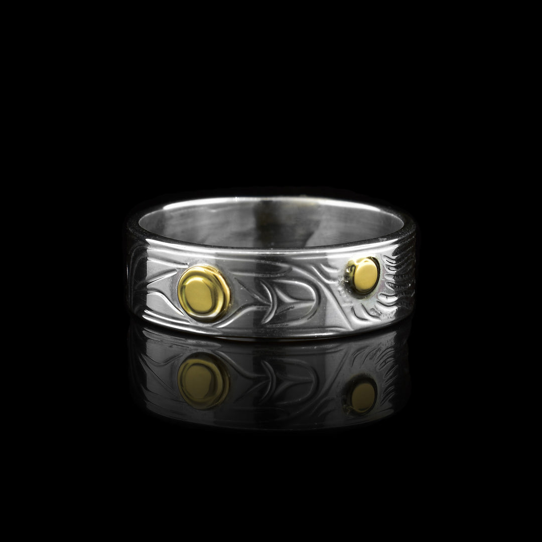This thin sterling silver 14k gold hummingbird band ring. On the thin band of sterling silver the legends of the raven of sun are carved onto it. To ad more detail the eye of the raven and the center of the sun are made with 14k gold.