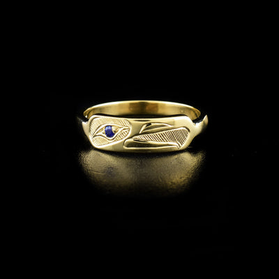 This 14K Gold Eagle Stacker Ring with Sapphire is hand-carved by Haisla artist, Hollie Bartlett.  She has used crosshatching to depict the face of an eagle with a sapphire set in the eye.  Size 7 available.     The Eagle Legend Represents: POWER, INTELLIGENCE, VISION.