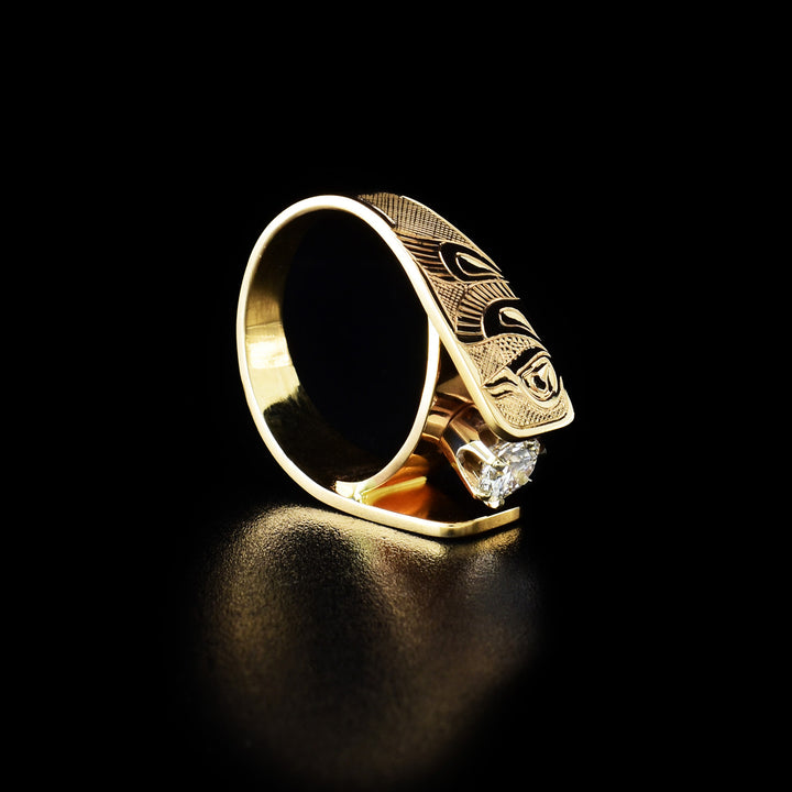 This Cathedral engagement ring has a 14K gold band with a hummingbird carved into both sides of the piece. The legends are in a side profile with their head looking up and wings and tail at the side. The bands extend up and frame the 0.5ct diamond set in the center.