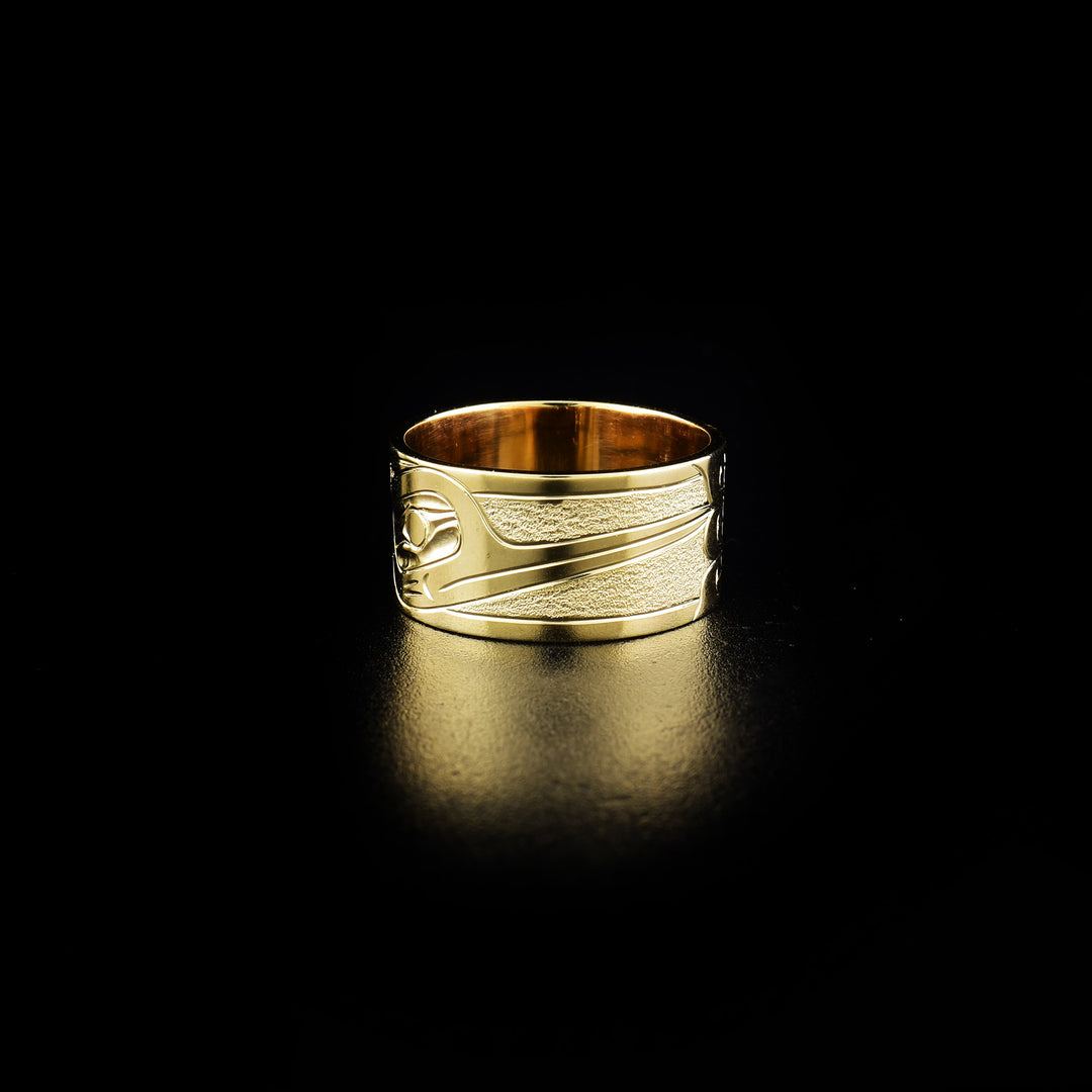 This 14K Gold Hummingbird Ring is hand carved by Kwakwaka'wakw artist Harold Alfred. The ring is available in a size 7 and is 3/8" wide. The design depicts the head of a hummingbird drinking from a flower.