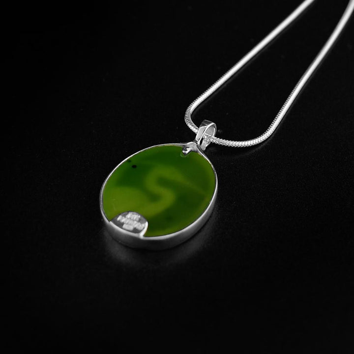 This jade pendant is made from sterling silver, 14K gold and A+ grade BC jade. There is a depiction of the Heron carved into a gold plate that is set on the jade giving the depiction gorgeous color.