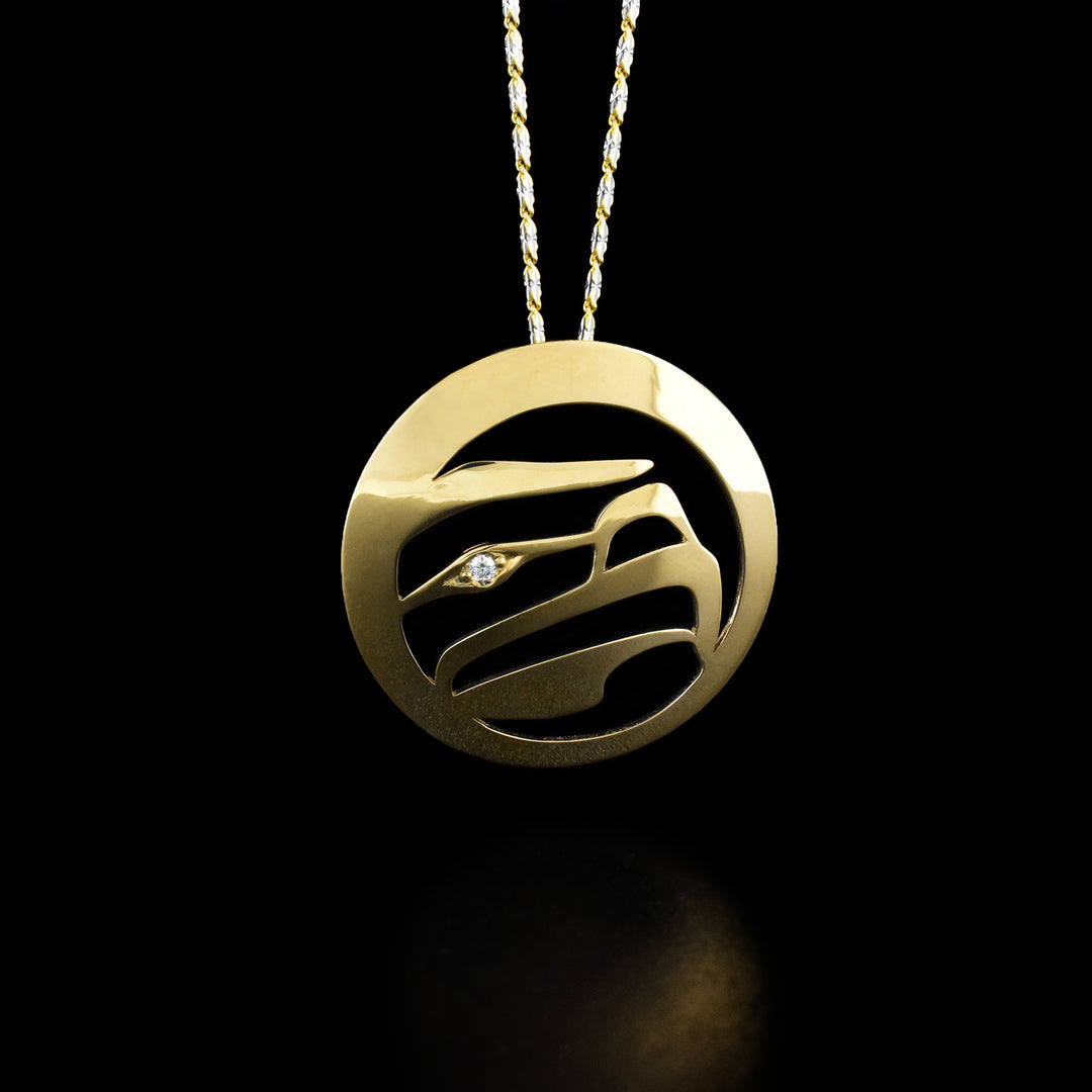 18K Gold Eagle Pendant with Diamond by Grant Pauls. The design depicts the profile of an eagle's head facing to the right with the background cutout. The artist has set a diamond in the eagle's eye.
