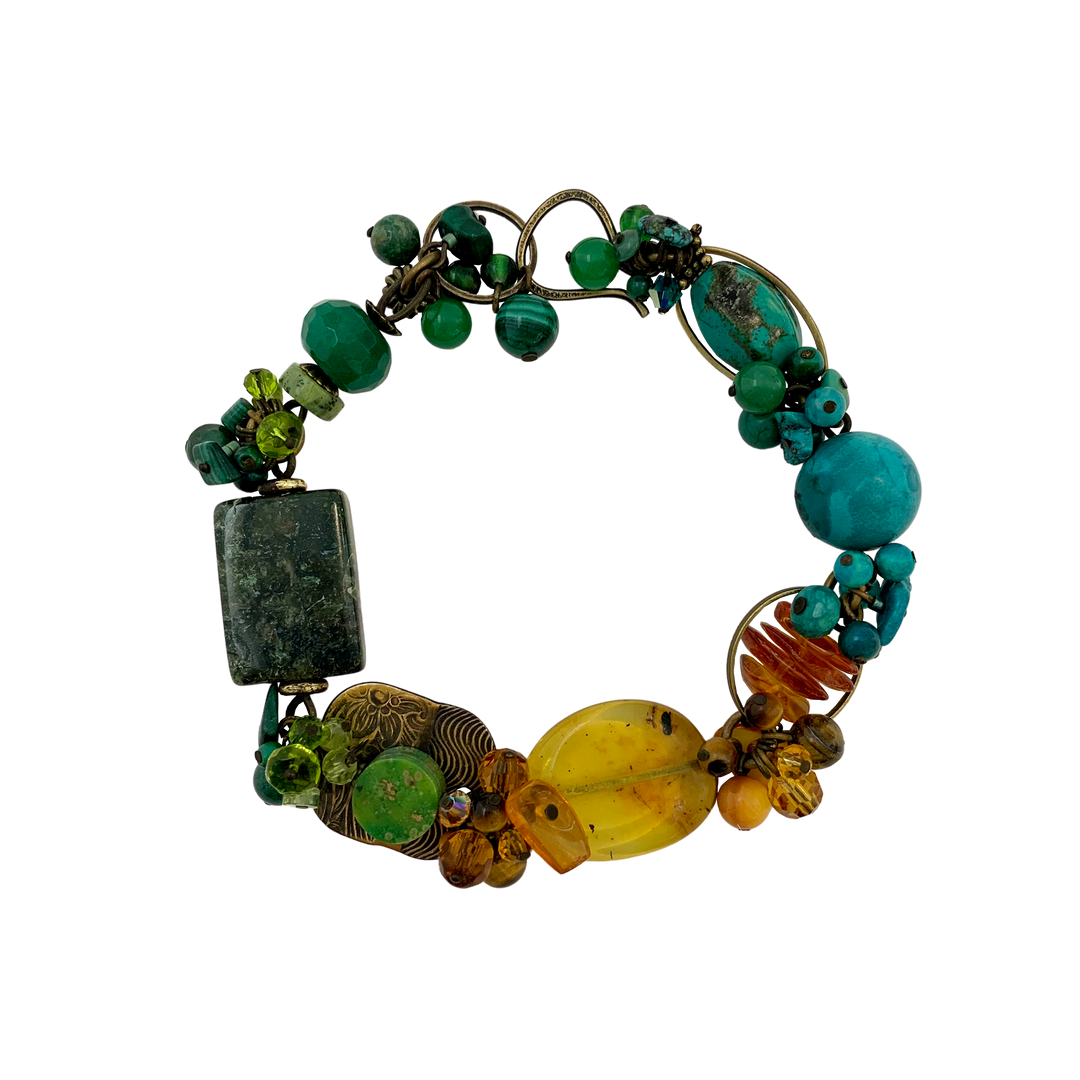 These gorgeous gemstone bead bracelets are made from Swarovski Crystal, Mother of Pearl, Hand worked Brass, Aventurine, Moss Agate, Peridot, BC Jade, Glass, Turquoise, Baltic Amber, Malachite, Agate and Magnesite. This piece features chunky beads of varying shape and material and the color of the bracelet transitions across the length of it.