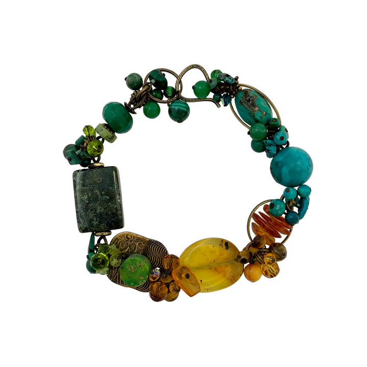 These gorgeous gemstone bead bracelets are made from Swarovski Crystal, Mother of Pearl, Hand worked Brass, Aventurine, Moss Agate, Peridot, BC Jade, Glass, Turquoise, Baltic Amber, Malachite, Agate and Magnesite. This piece features chunky beads of varying shape and material and the color of the bracelet transitions across the length of it.