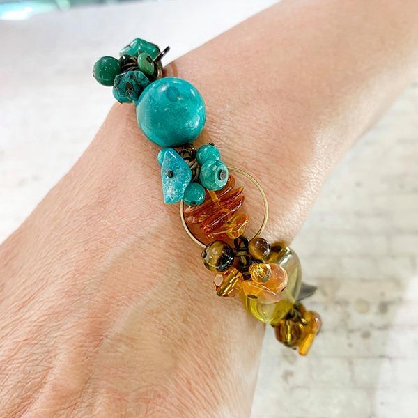 These gorgeous gemstone bead bracelets are made from Swarovski Crystal, Mother of Pearl, Hand worked Brass, Aventurine, Moss Agate, Peridot, BC Jade, Glass, Turquoise, Baltic Amber, Malachite, Agate and Magnesite. This piece features chunky beads of varying shape and material and the color of the bracelet transitions across the length of it.