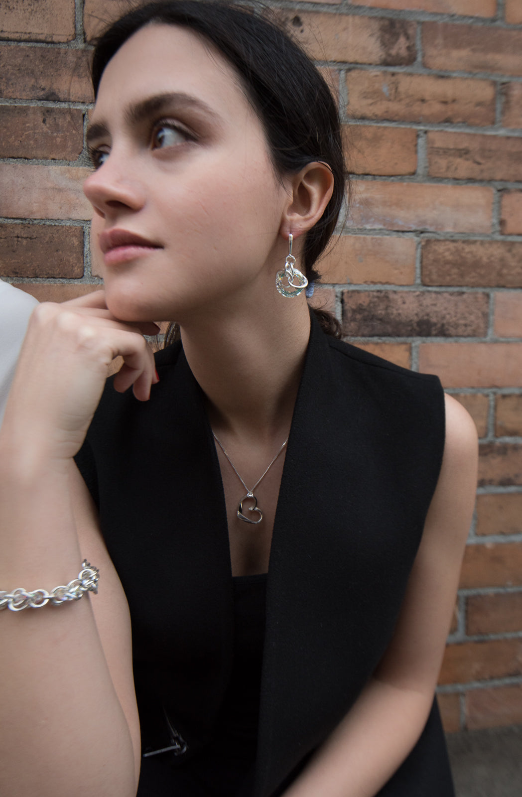 These crystal dangle earrings are made from sterling silver and aurora borealis Swarovski crystals. The hangs have a large, hoop shaped crystal with several silver hoops linked around it.
