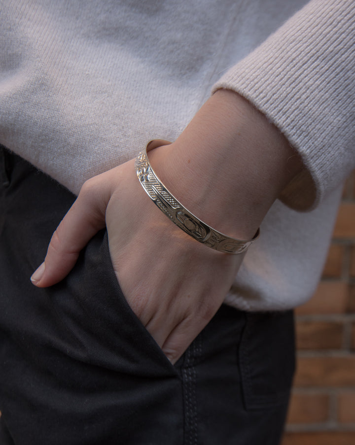 The white gold cuff bracelet on the hand of a model.