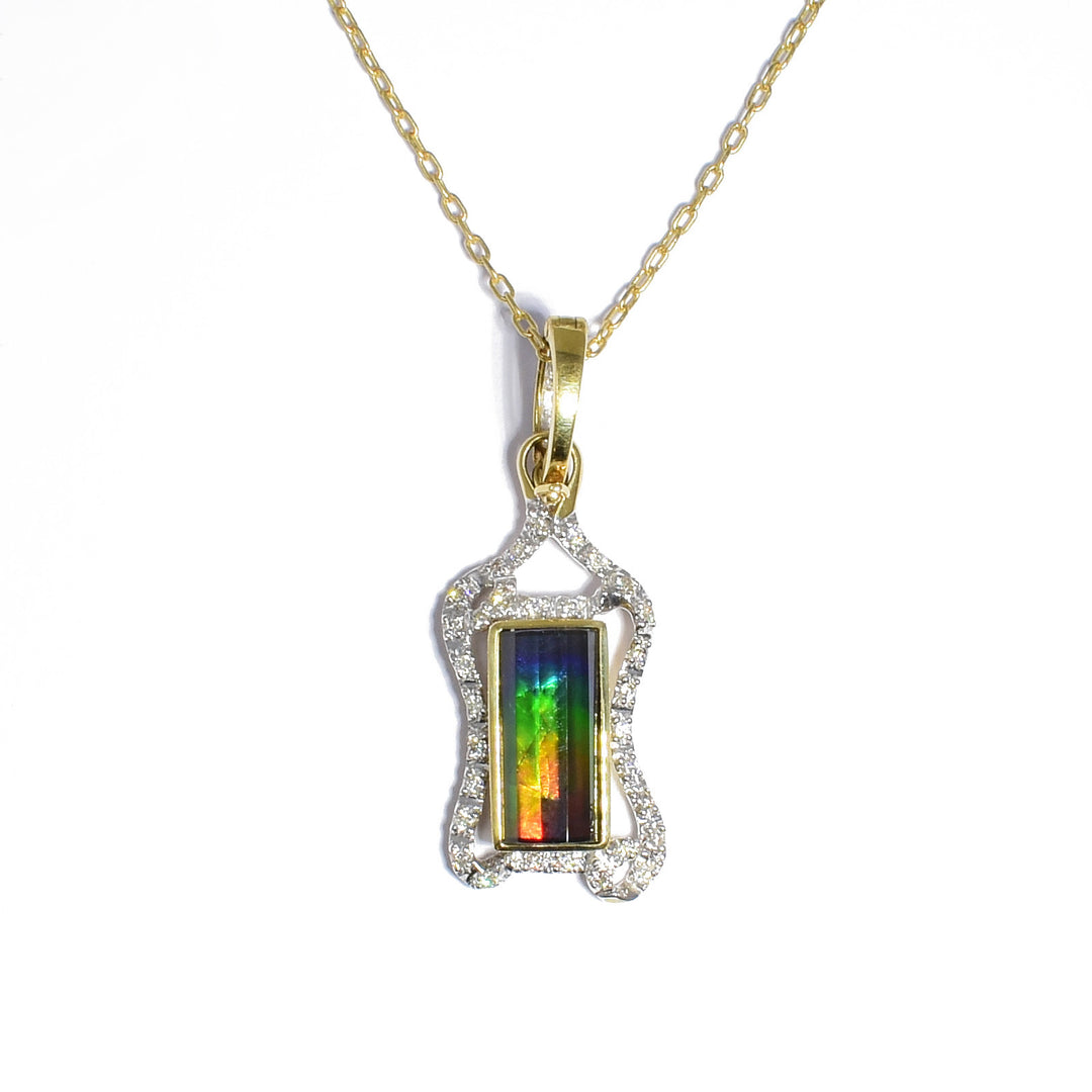 14K gold ammolite pendant by Korite. It features a rectangular, faceted grade AA ammolite stone. The stone boasts a stunning array of colours, mainly blue, green, yellow and red. The rest of the pendant is made up of 14K yellow gold and diamonds. Pendant measures 1.44" x 0.50" including bail. Chain not included.