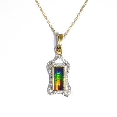 14K gold ammolite pendant by Korite. It features a rectangular, faceted grade AA ammolite stone. The stone boasts a stunning array of colours, mainly blue, green, yellow and red. The rest of the pendant is made up of 14K yellow gold and diamonds. Pendant measures 1.44" x 0.50" including bail. Chain not included.