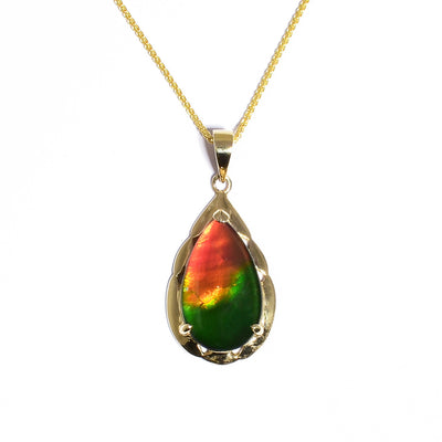 Dazzling teardrop ammolite pendant by Korite. Made of grade A ammolite and 14K yellow gold. Stone mainly shines green and red but has tinges of blue as well. Pendant measures 1.19" x 0.56" including bail. Chain not included.