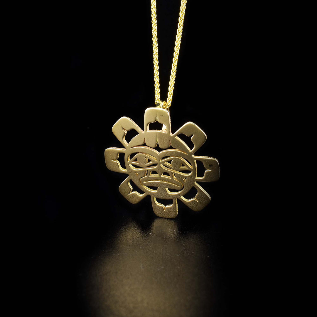 This 14K gold Sun pendant is shaped like and has cutouts on the surface depicting the Sun.