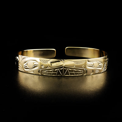 Wolf and bear cuff bracelet hand-carved by Kwakwaka'wakw artist Harold Alfred. Made of 14K gold. Bracelet is 6.13" long with 0.25" gap and has width of 0.38".