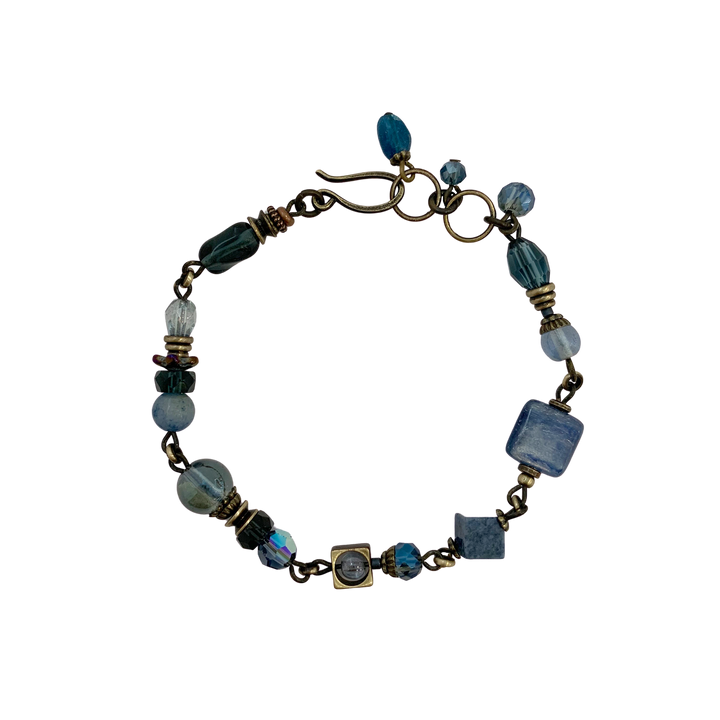 This blue crystal bracelet is made from  Austrian crystal, faceted glass, dumortierite, aventurine, apatite, kyanite and glass. The brass chain bracelet features beads of different shapes and materials.