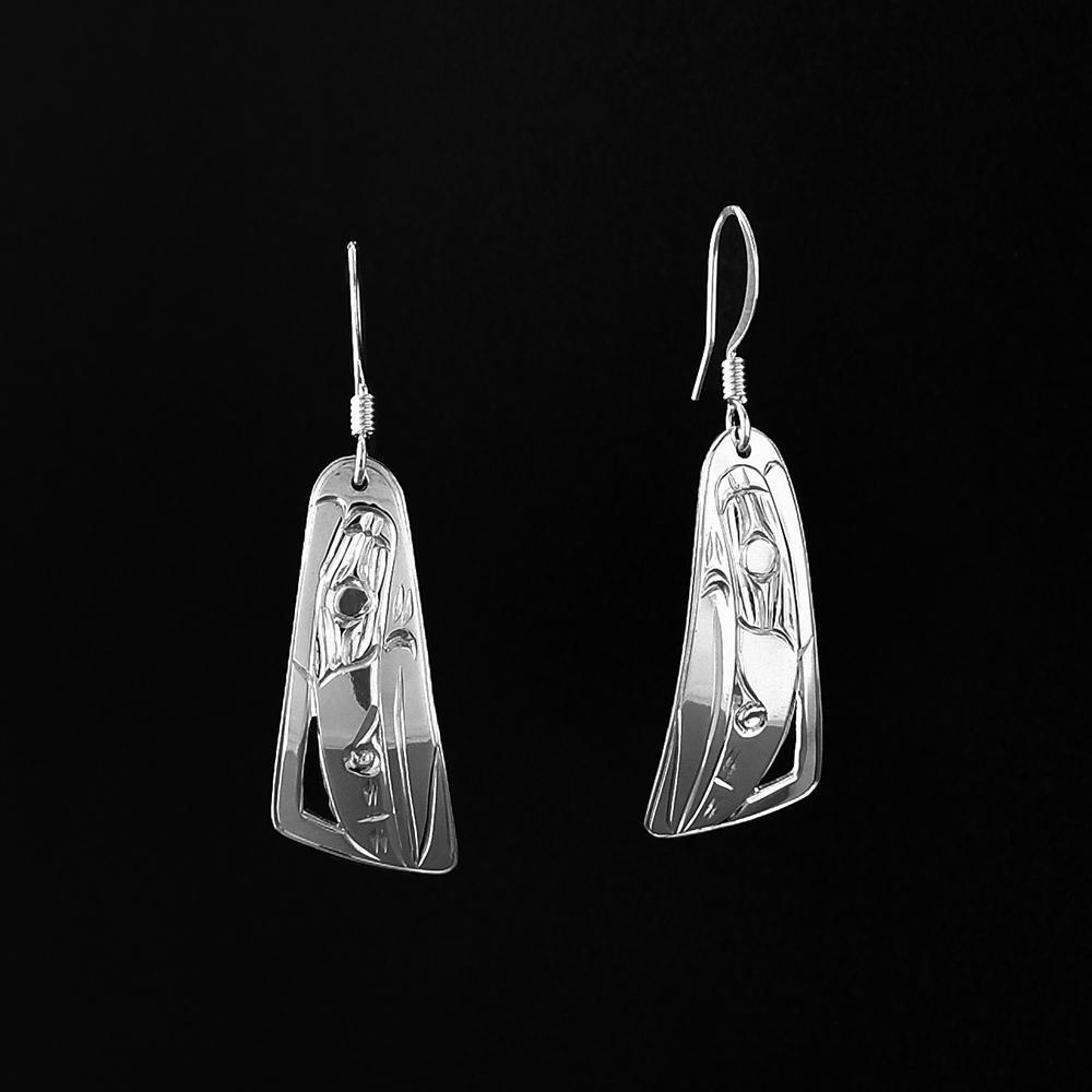 These dangling Raven earrings are made from sterling silver and have long, tapered hangs. There are depictions of the Raven carved into the surface of the hangs.