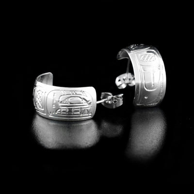 Sterling Silver 3/8" Orca Hoop Earrings by Jeffrey Pat. The artist has hand-carved the profile of an orca's head at the top of the hoop. The remainder of each earring has intricate designs representing the orca's body and fins.