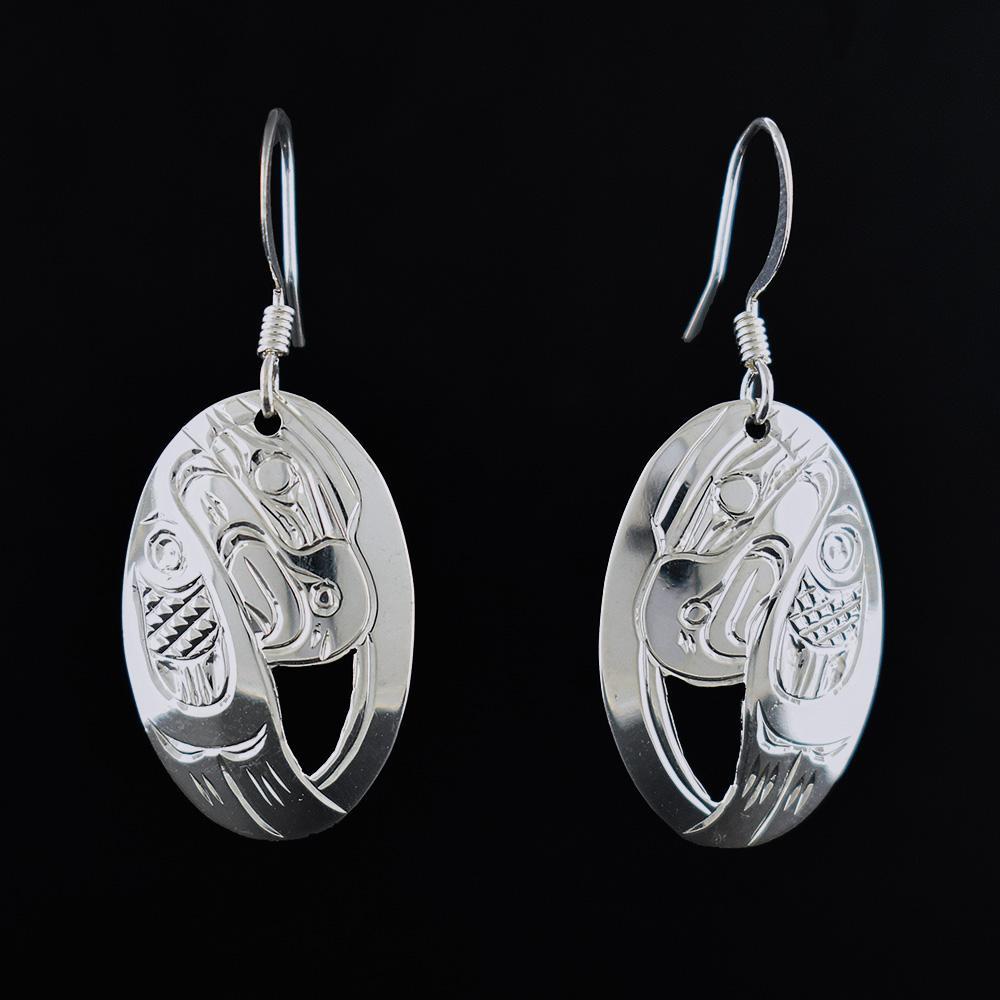 These Eagle earrings are made from sterling silver and have oval shaped hangs. There are cutouts and carvings on the surface of the hangs that depict the Eagle.