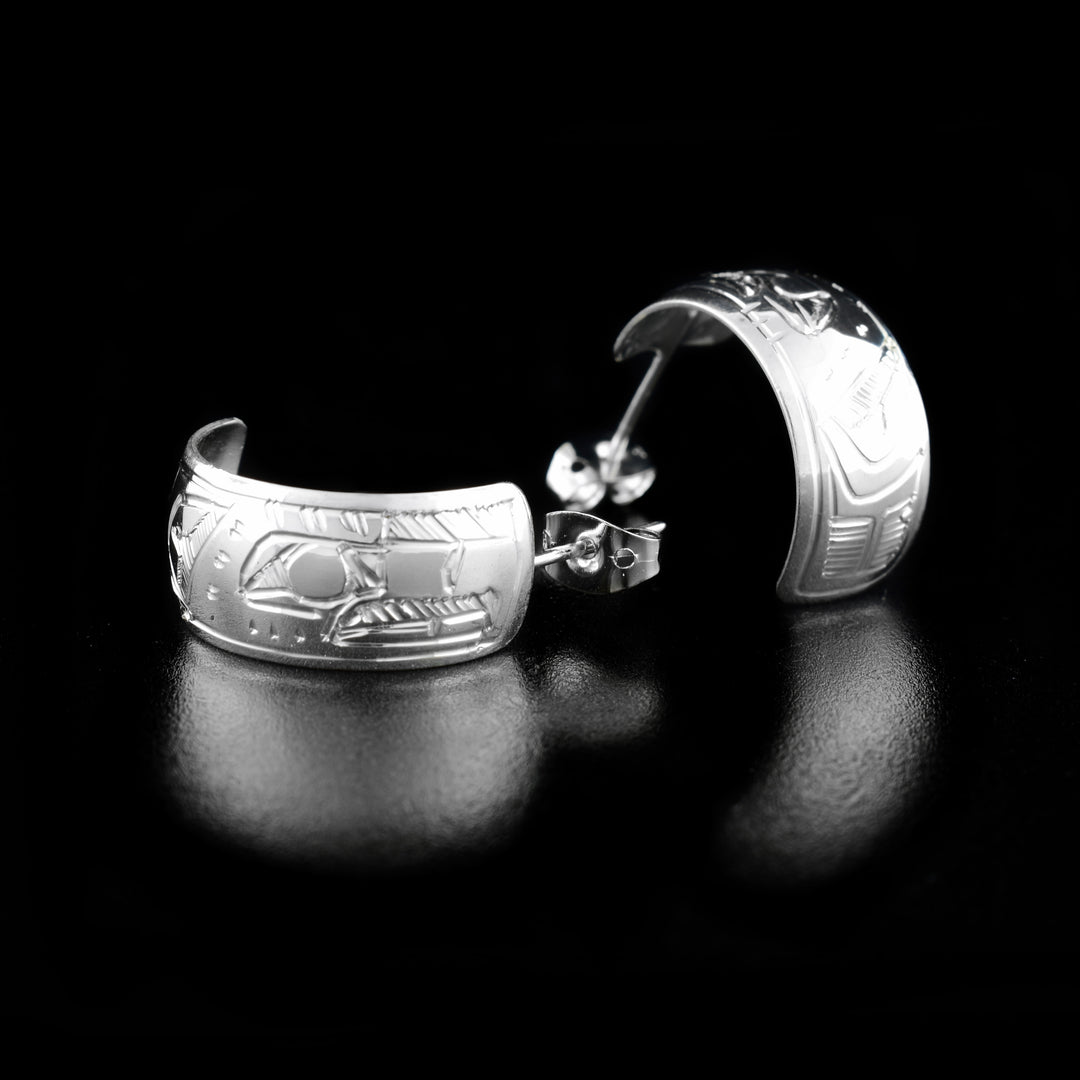 These Eagle earrings are made from sterling silver and they have thick bands that wrap into hoops. There are depictions of the Eagle carved into the surface of the hoops.