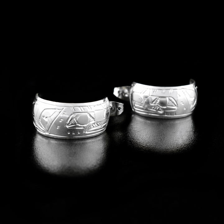 These Eagle earrings are made from sterling silver and they have thick bands that wrap into hoops. There are depictions of the Eagle carved into the surface of the hoops.