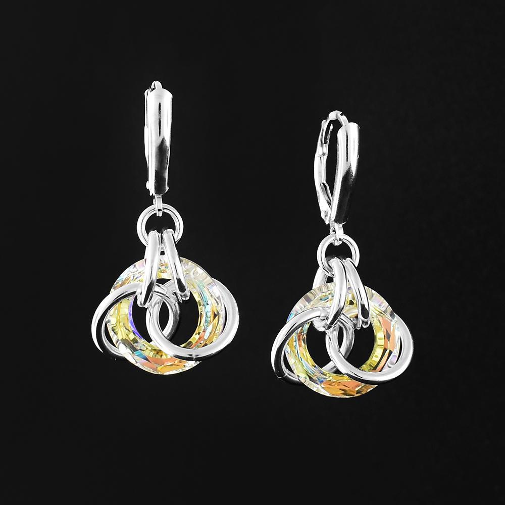 These crystal dangle earrings are made from sterling silver and aurora borealis Swarovski crystals. The hangs have a large, hoop shaped crystal with several silver hoops linked around it.
