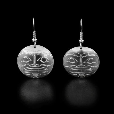 These moon dangle earrings are round in shape and have the full face of a moon with large eyes, a nose, and teeth looking forward.