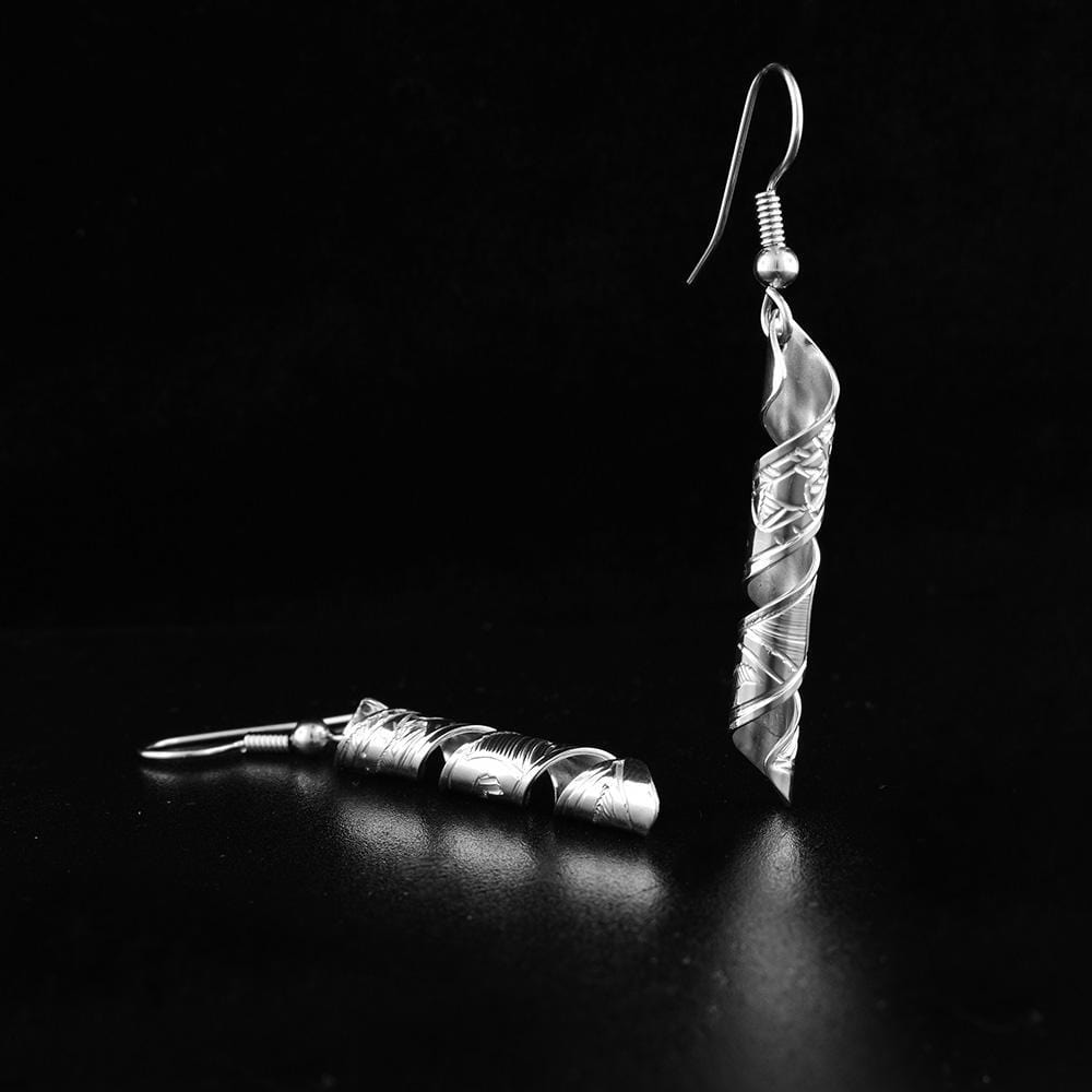 These dangling spiral earrings are made from sterling silver and have long, thin hangs. The hangs are made by coiling a band into an elegant spiral shape and there are carvings on the surface of them depicting the Raven.