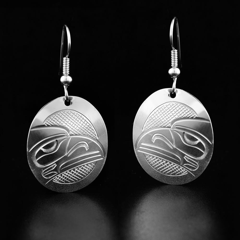 These dangling Raven earrings are made from sterling silver and have oval shaped hangs. There are depictions of the Raven carved into the surface of the hangs.