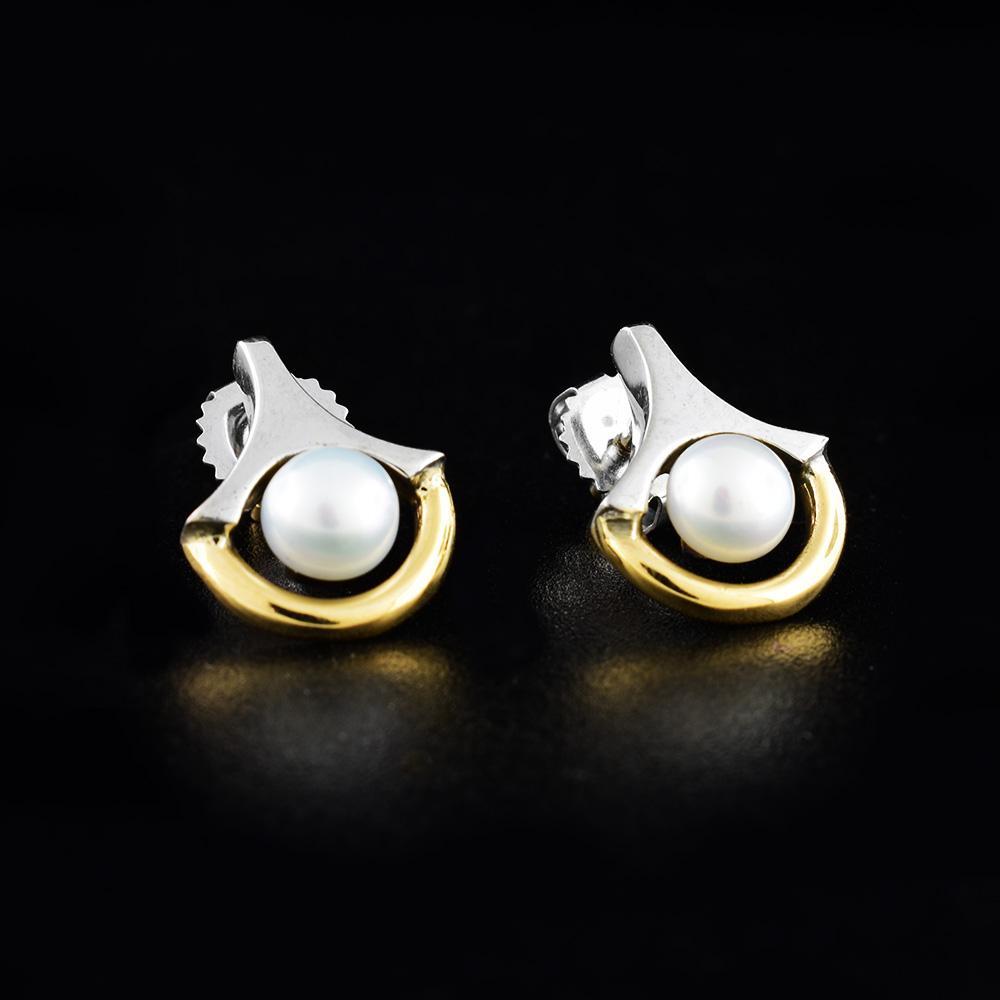 These freshwater pearl stud earrings have sterling silver cradles holding the pearls and a 14K gold wire running along it.