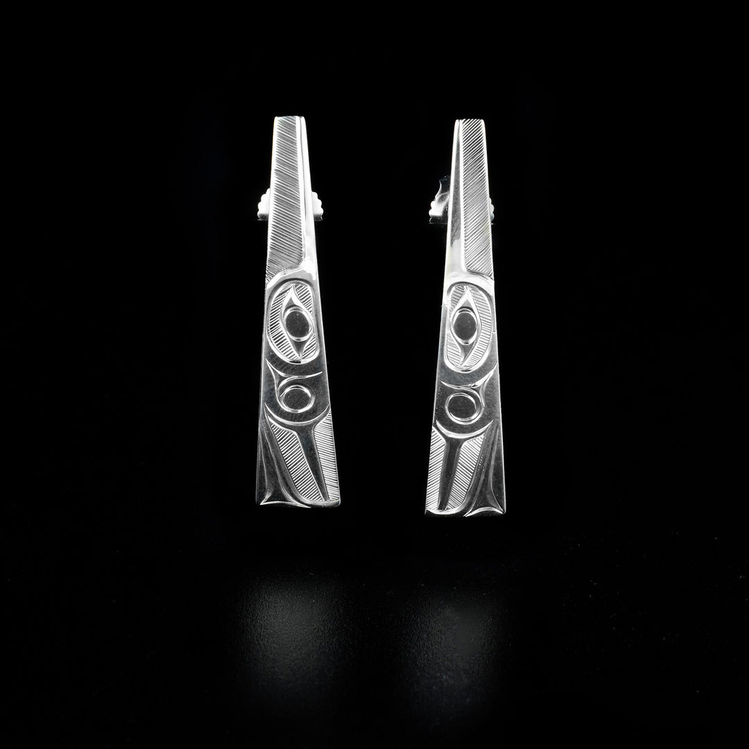These Sterling Silver Tapered Hummingbird Post Earrings are hand-carved by Haisla artist, Hollie Bartlett.  She has used crosshatching to depict the face of a hummingbird on each earring.  Each earring measures 1.45" x 0.25".     The Hummingbird Legend Represents: BEAUTY, LOVE, HARMONY.
