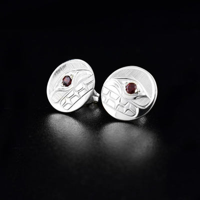These sterling silver stud earrings hold the shape of the Orca with garnet stone eyes. Both earrings measure 1/2" in diameter.
