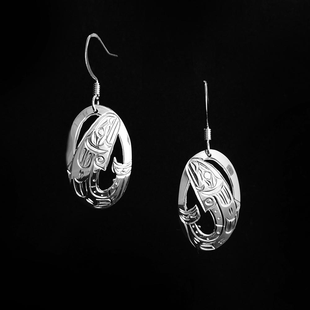 These unique Salmon fish earrings are made from sterling silver and have oval shaped hangs. The hangs are cutout and have carvings on the surface of them that depict the Salmon.