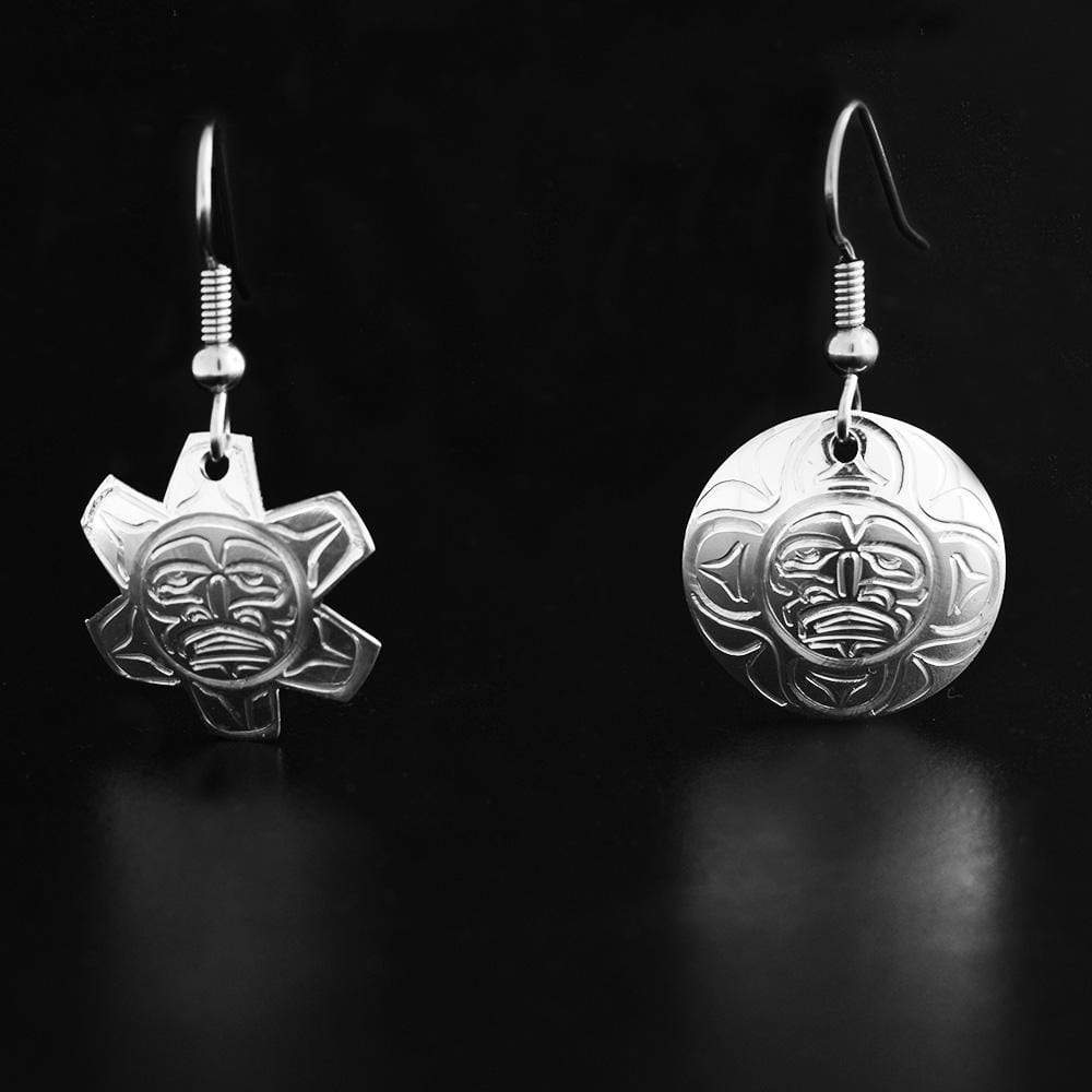 These dangling Moon and Sun earrings are made from sterling silver and have circular hangs. One of the earrings is shaped like and has depictions carved into it that depict the Sun and the other earrings depicts the Moon.