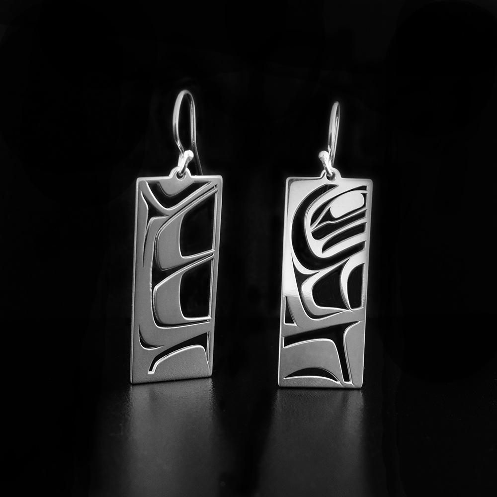These dangling Raven earrings are made from sterling silver and have rectangle hangs. There are cutout designs that depict the Raven cast into the hangs.