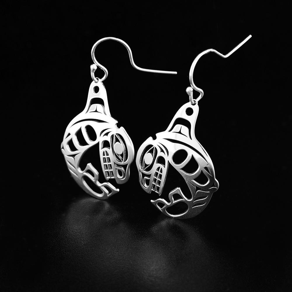 Sterling silver dangle earrings. Each earring is in the shape of the Orca. Throughout the Orca's body the artist has created cut outs to represent the intricate details and unique spots found on an Orca.