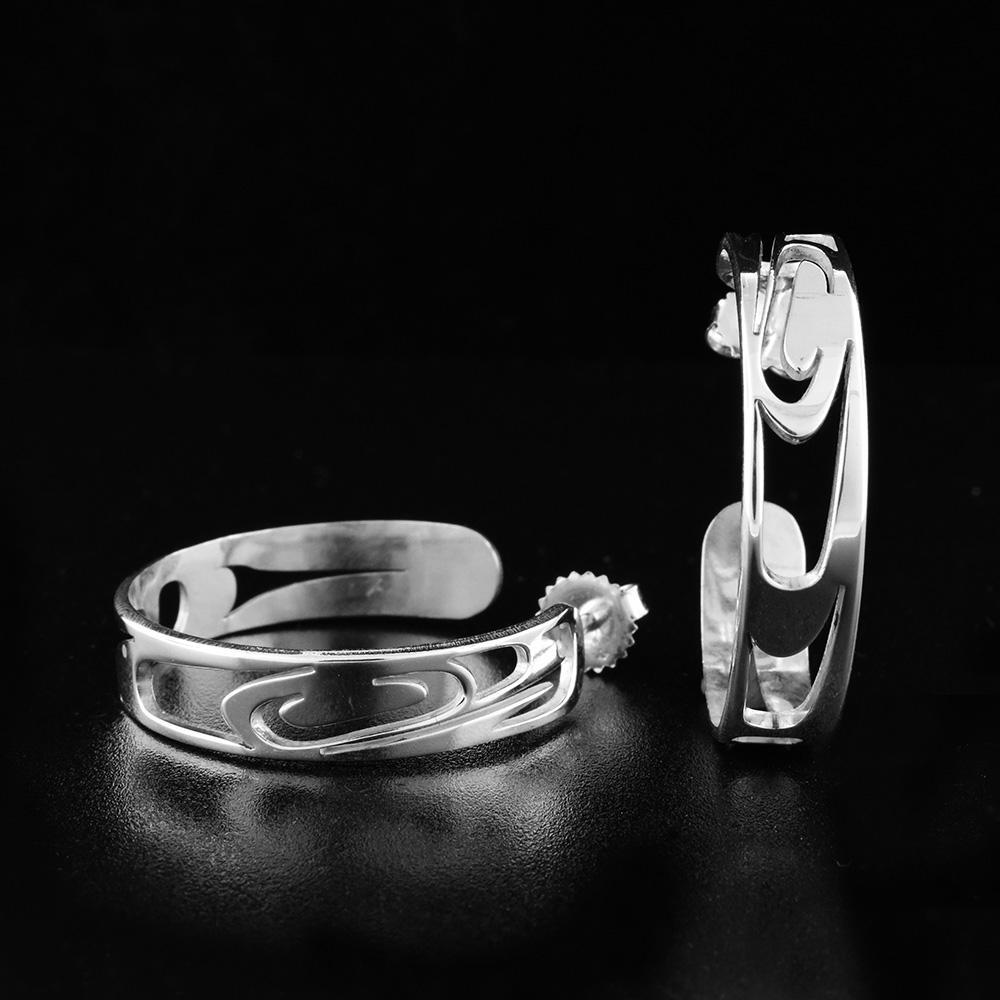 This sterling silver hoop earrings have cutout designs on the surface of the hoops that depict the Orca.