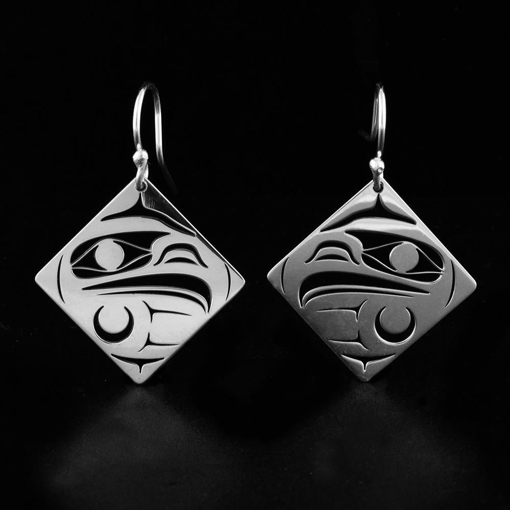 These dangling, diamond shaped earrings are made from sterling silver and have cutout designs on the hangs that depict the Eagle.