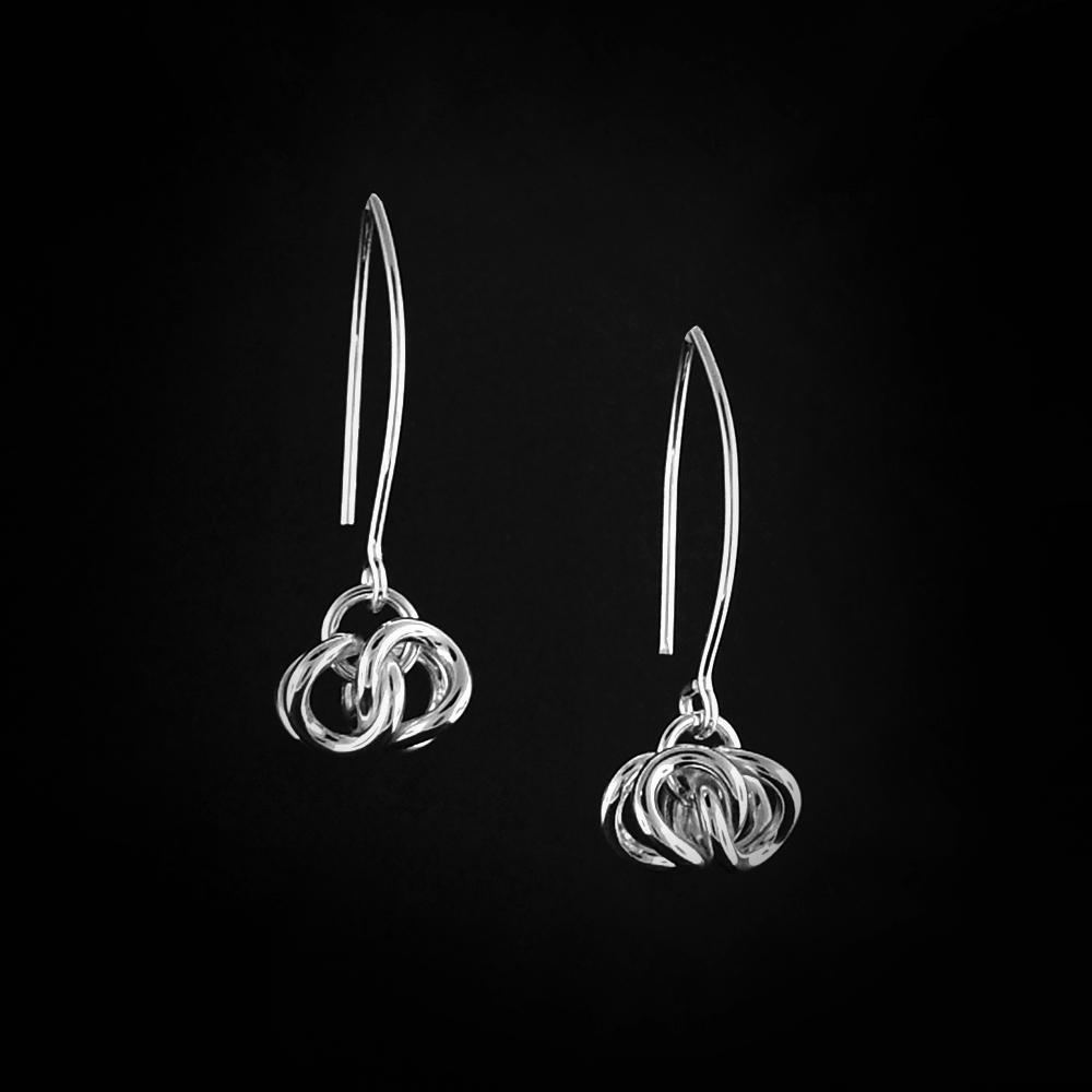 These dangle hoop earrings are made from sterling silver. The earrings have dangles made from several small, silver hoops that are interlocked together.