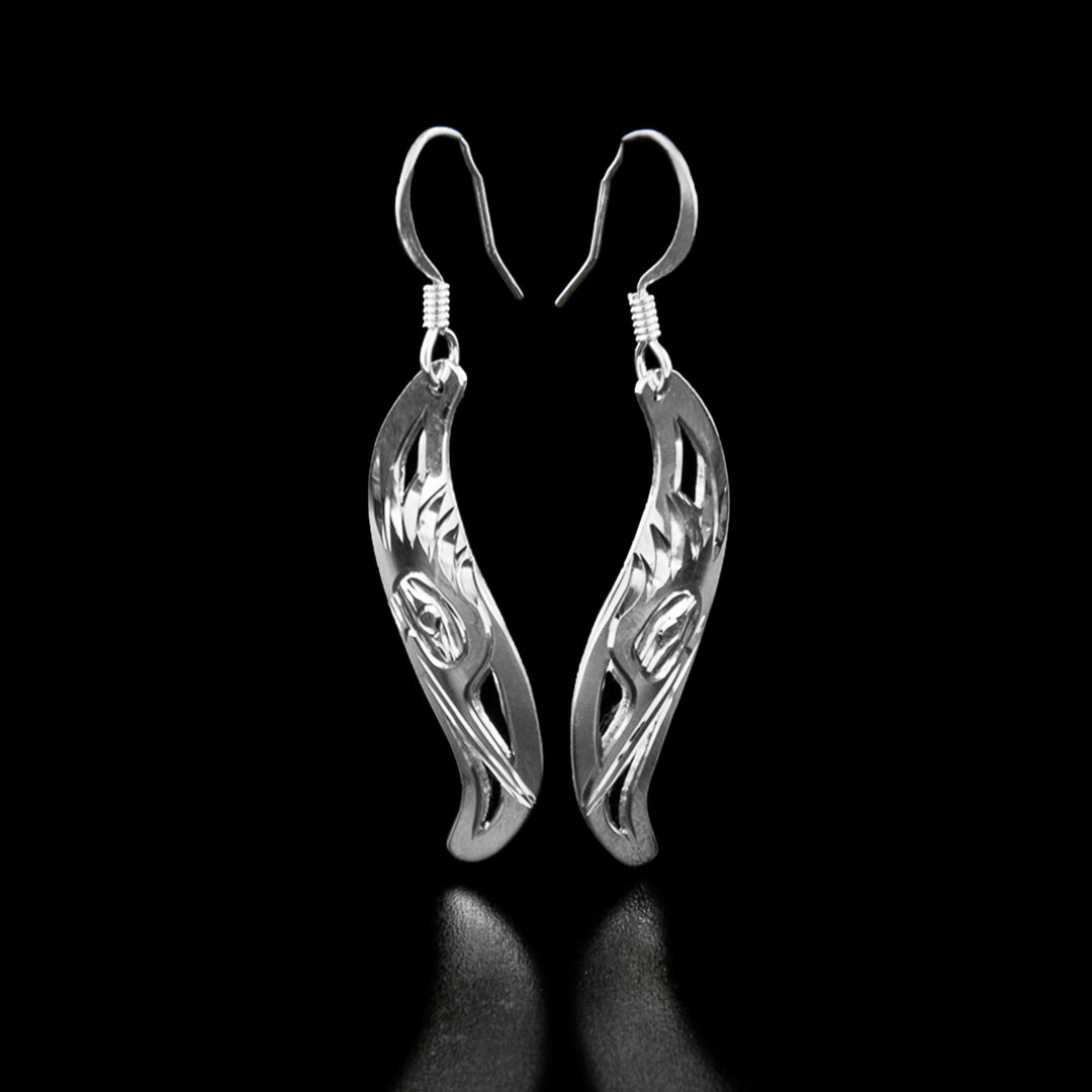 Sterling Silver Leaf Style Kingfisher Earrings by Harold Alfred. Each earring is in the shape of a leaf. The artist has hand-carved the profile of a kingfisher's head facing downward. The kingfisher has a long, narrow beak and a bunch of ruffled feathers on the top of its head. The background is been cut out.