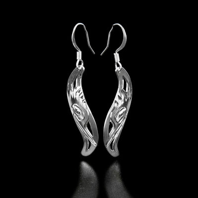 Sterling Silver Leaf Style Kingfisher Earrings by Harold Alfred. Each earring is in the shape of a leaf. The artist has hand-carved the profile of a kingfisher's head facing downward. The kingfisher has a long, narrow beak and a bunch of ruffled feathers on the top of its head. The background is been cut out.