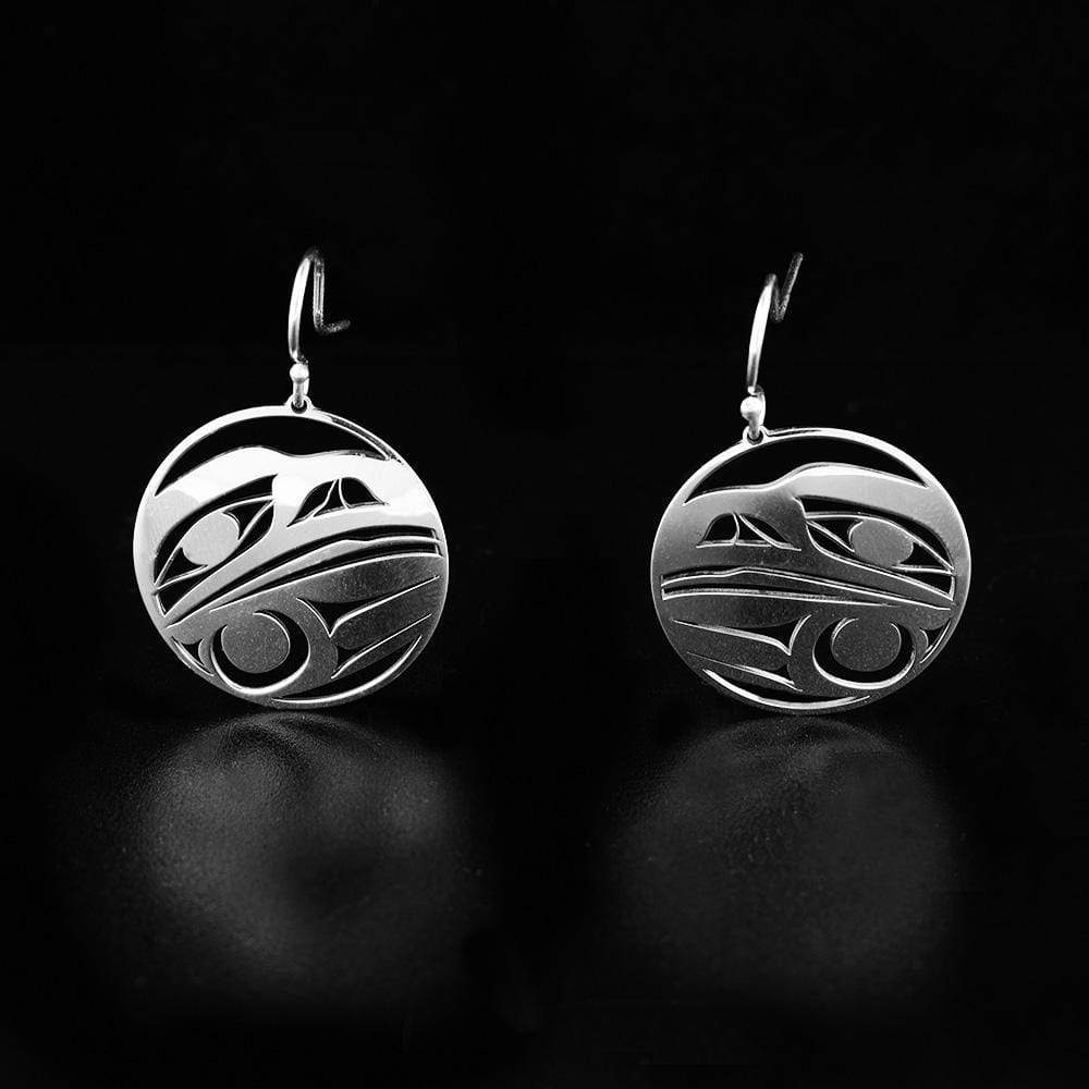 This sterling silver dangle earrings have circle hangs with cutout designs that depict the head of the Raven.
