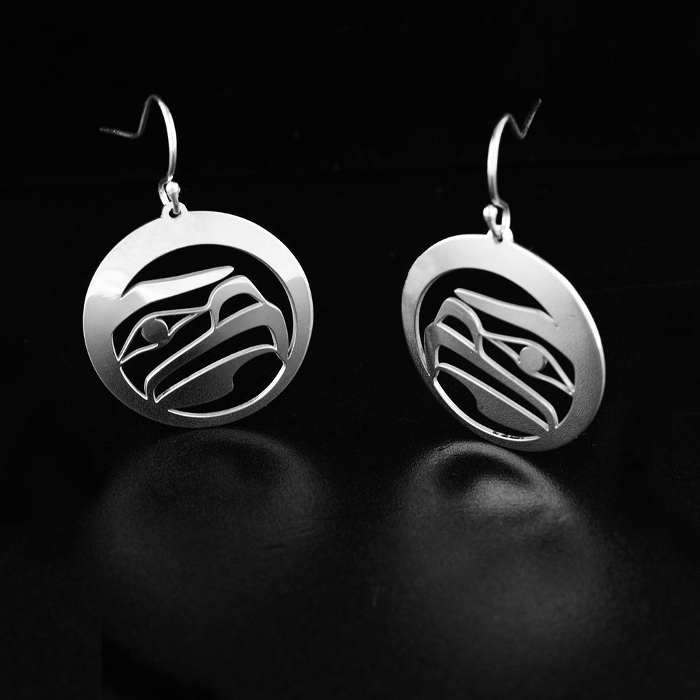 These dangling Eagle earrings are made from sterling silver and have circle shaped hangs. There are cutout designs on the hangs that depict the Eagle.