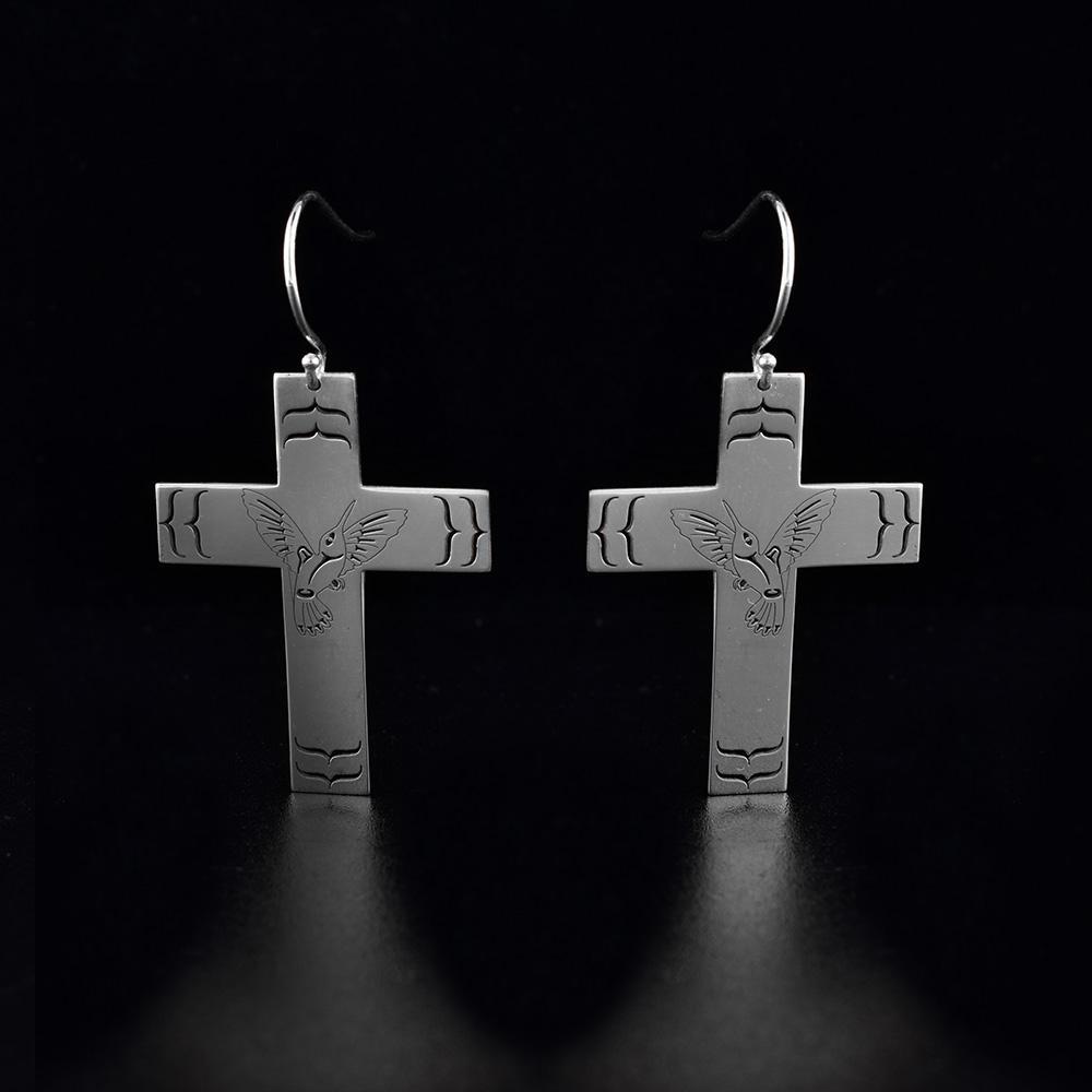 These sterling silver, dangling Hummingbird earrings have hangs shaped like a cross. There is a depiction of the Hummingbird cast into the center of the hangs and designs around it.