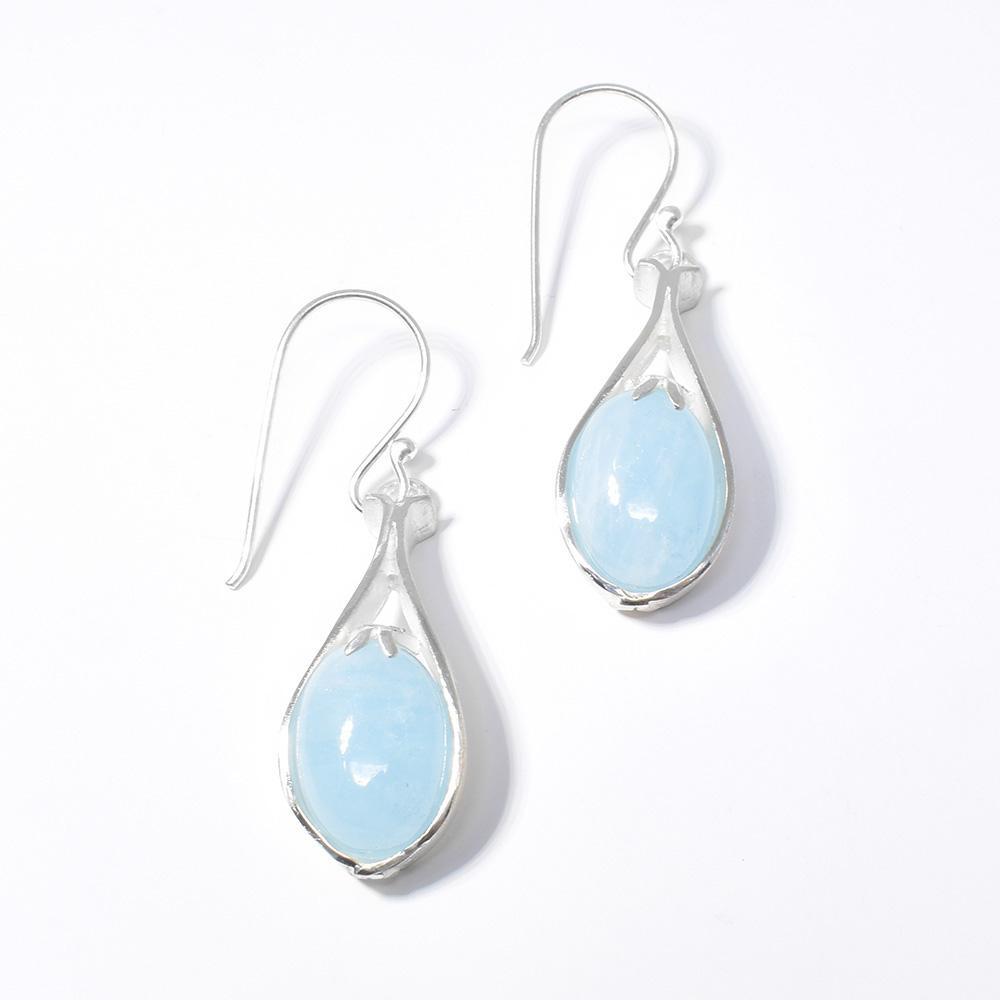 These aquamarine earrings have gems that are held in beautifully designed, silver cradles. The hangs have a teardrop shape to them.