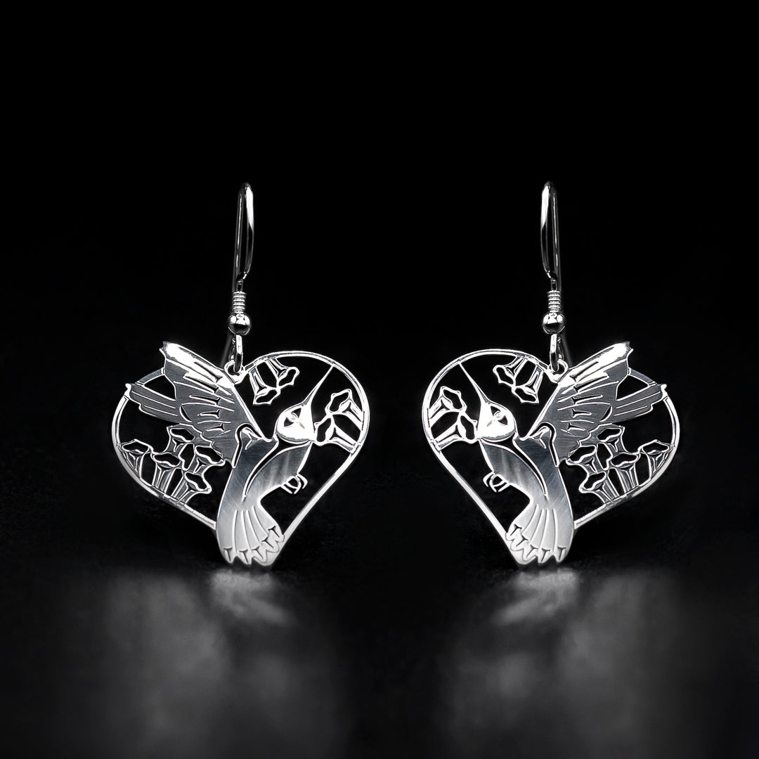 These sterling silver heart earrings have heart shaped hangs with cutout designs depicting the Hummingbird. There are designs that have been cast into the surface of the hangs.