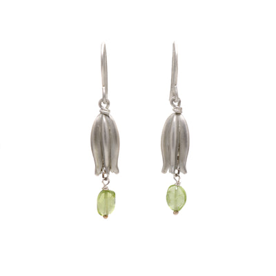 These peridot earrings are each in the shape of a bell-shaped flower with a peridot attached at the bottom. 