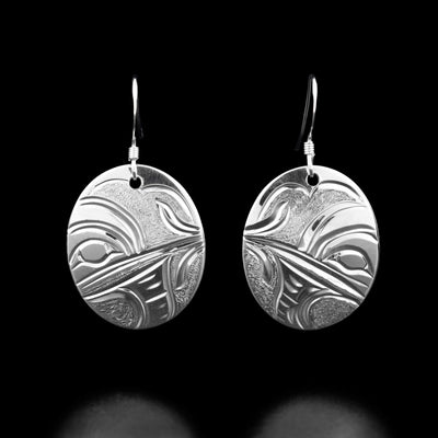 These hummingbird earrings are oval shaped and have the profile of a hummingbird's head facing inward and drinking from a small flower.