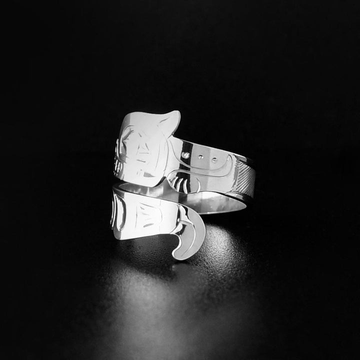 This Otter ring is made from sterling silver and has a single band that wraps around the finger twice. The band is shaped like and has carvings depicting the Otter. The head is shown on the top band and its tail is depicted at the bottom.